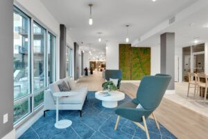 Modern lobby with stylish seating, large windows, and a green wall accent, offering a bright and inviting atmosphere.