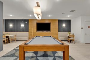 Modern recreation room with a pool table, wall-mounted TV, and cozy seating area for social gatherings.