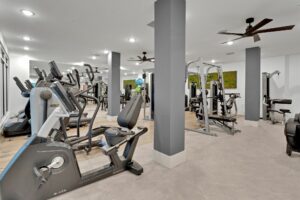 Modern gym equipped with exercise machines and cardio equipment in a spacious, well-lit room.