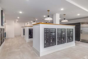 Modern apartment mailroom with sleek mailboxes and ambient lighting.